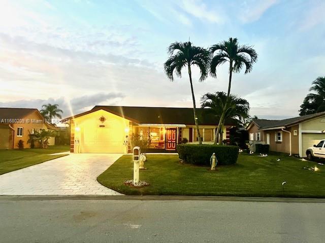 ranch-style home with a front yard and a garage