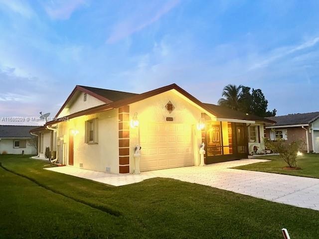 property exterior at dusk featuring a yard and a garage