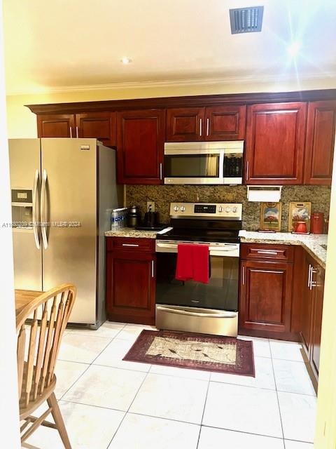 kitchen featuring backsplash, appliances with stainless steel finishes, and light tile patterned floors