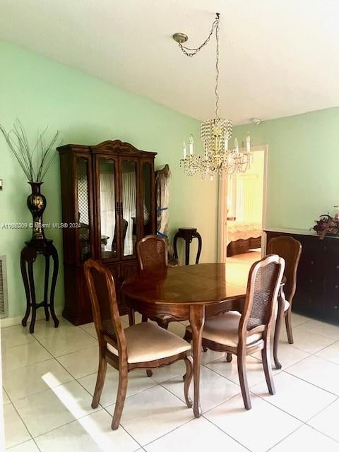 tiled dining space featuring a chandelier