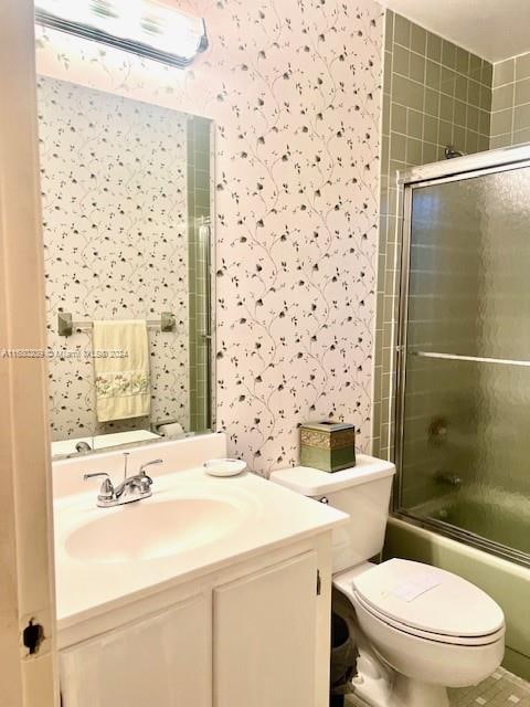 full bathroom with vanity, toilet, and enclosed tub / shower combo