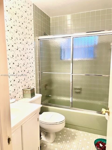 full bathroom with toilet, bath / shower combo with glass door, vanity, and tile patterned floors