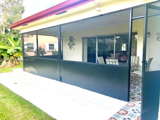 view of property exterior featuring a sunroom