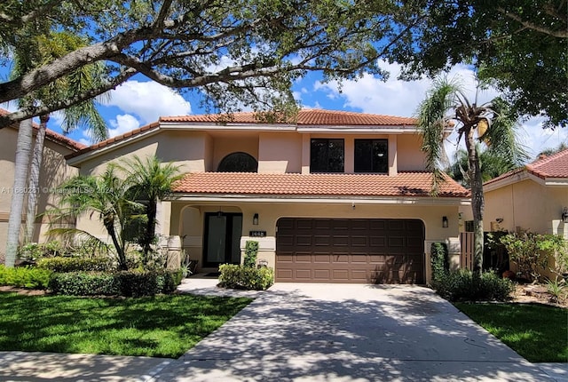 mediterranean / spanish-style house featuring a front lawn and a garage