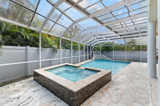 view of pool featuring a patio, a lanai, and an in ground hot tub