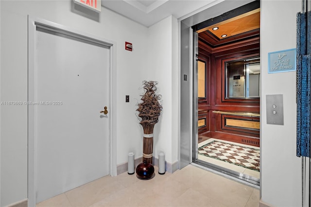 entrance foyer featuring light tile patterned floors and elevator