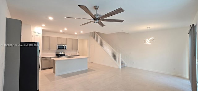 kitchen with a kitchen island with sink, gray cabinets, stainless steel appliances, and sink