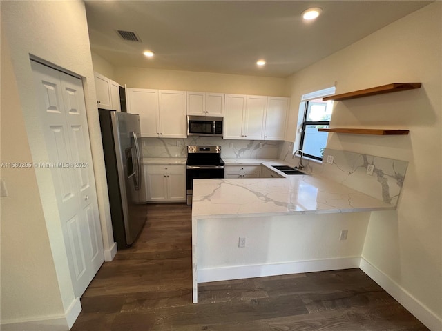 kitchen featuring white cabinetry, dark wood-type flooring, stainless steel appliances, tasteful backsplash, and kitchen peninsula