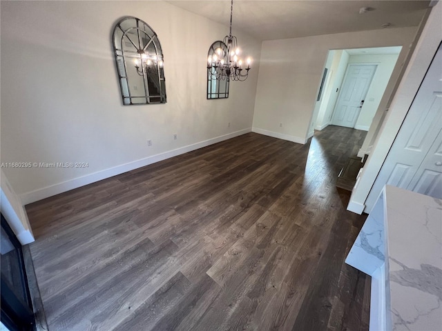 unfurnished dining area featuring dark hardwood / wood-style floors and an inviting chandelier