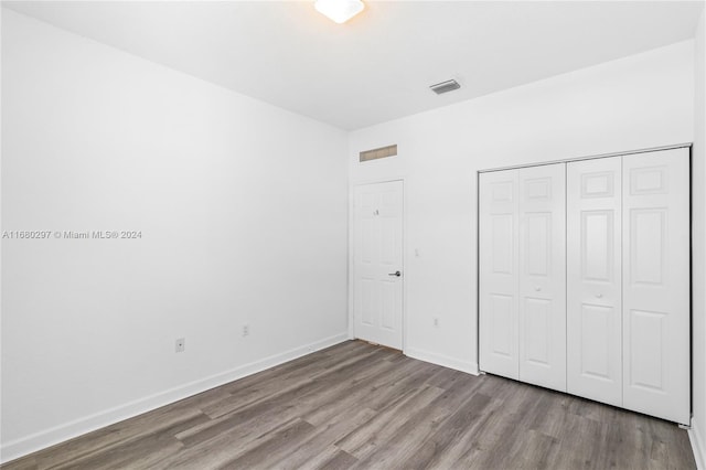 unfurnished bedroom featuring a closet and light wood-type flooring