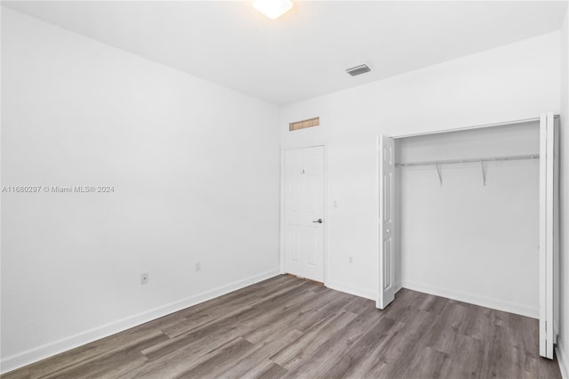 unfurnished bedroom with wood-type flooring and a closet