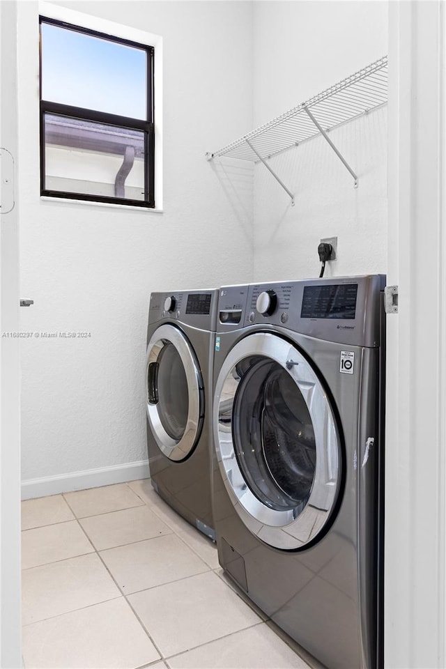 laundry room with light tile patterned flooring and washing machine and dryer