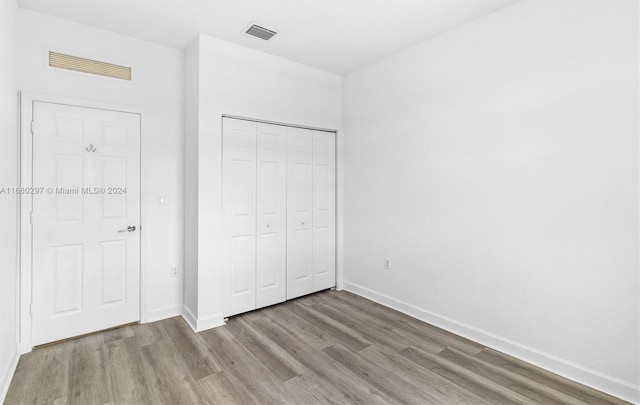 unfurnished bedroom featuring a closet and hardwood / wood-style floors