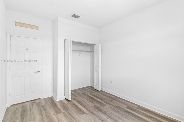 unfurnished bedroom with a closet and light hardwood / wood-style floors