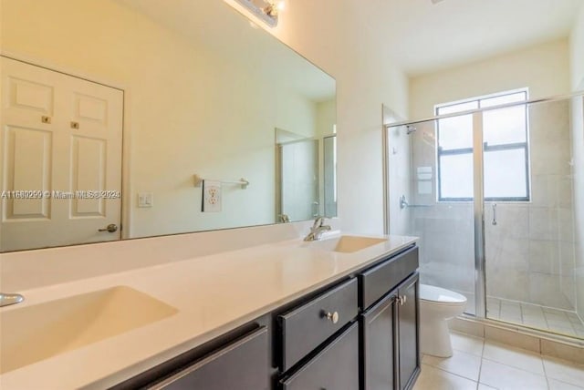 bathroom featuring vanity, toilet, tile patterned floors, and a shower with shower door