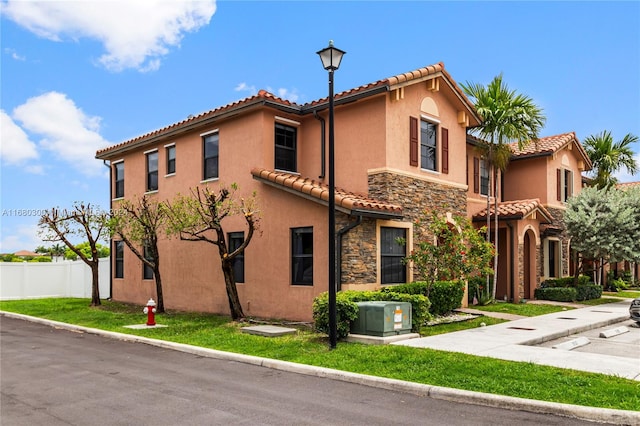 mediterranean / spanish home with a front lawn