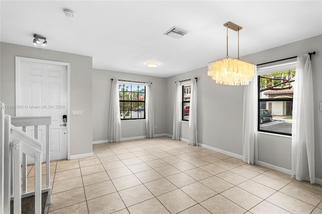 interior space featuring a notable chandelier and light tile patterned floors