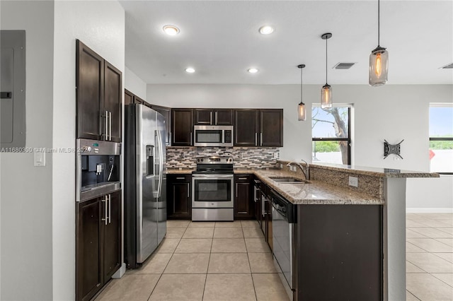 kitchen with appliances with stainless steel finishes, sink, plenty of natural light, and decorative light fixtures