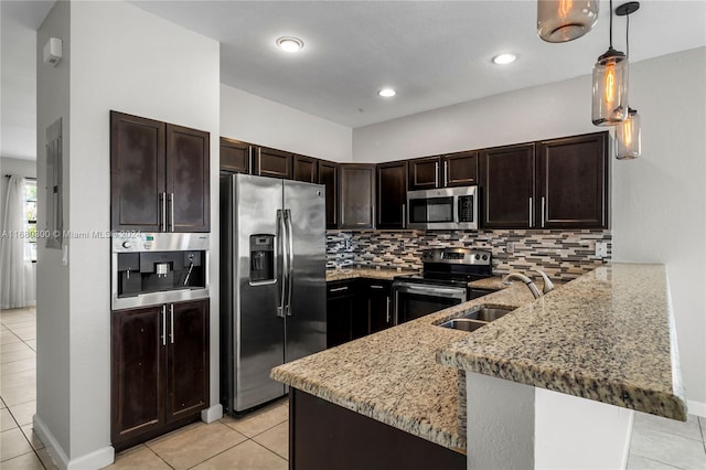 kitchen with kitchen peninsula, stainless steel appliances, sink, a breakfast bar, and decorative light fixtures