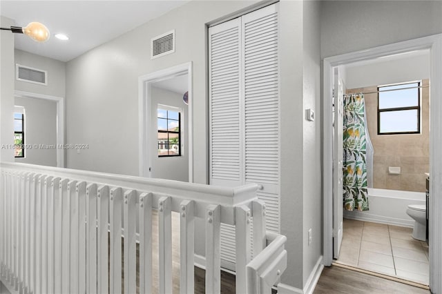 corridor with a wealth of natural light and tile patterned floors