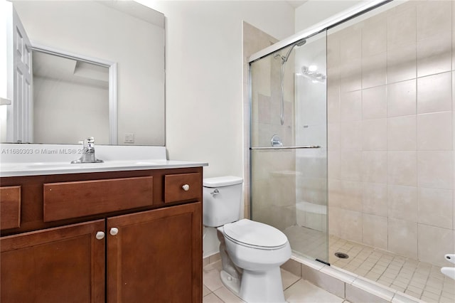 bathroom with toilet, a shower with shower door, vanity, and tile patterned floors