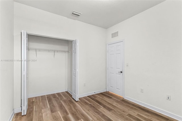 unfurnished bedroom with wood-type flooring and a closet