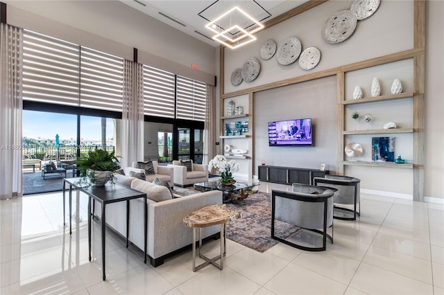 tiled living room featuring a towering ceiling and an inviting chandelier