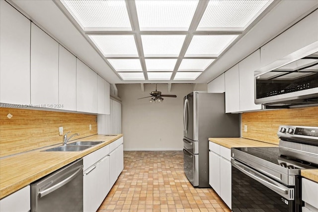 kitchen featuring sink, ceiling fan, tasteful backsplash, white cabinetry, and stainless steel appliances