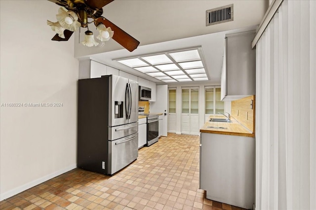 kitchen with ceiling fan, sink, and stainless steel appliances