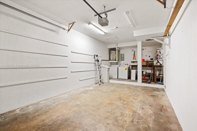 garage with separate washer and dryer and a garage door opener