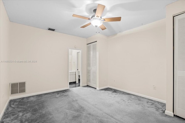 unfurnished bedroom featuring ceiling fan and dark carpet