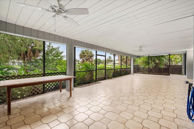 unfurnished sunroom with ceiling fan