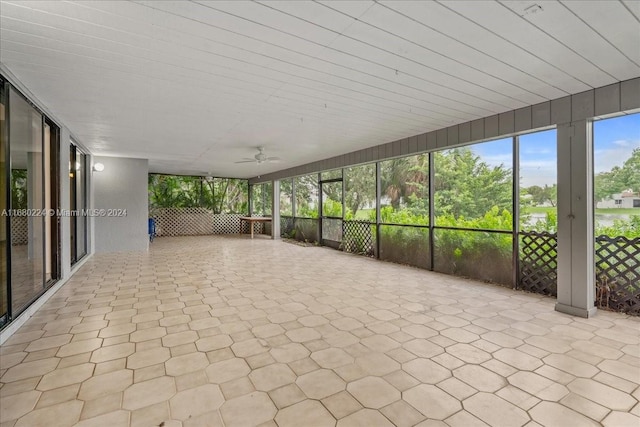 unfurnished sunroom featuring ceiling fan