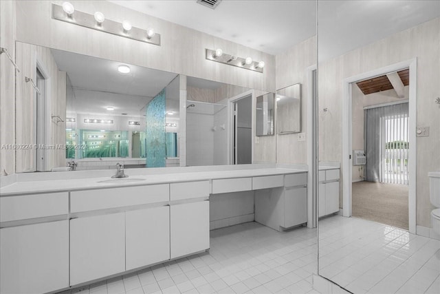 bathroom featuring tile patterned flooring, vanity, toilet, and a tile shower