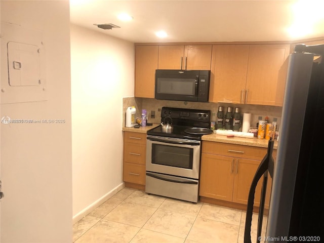 kitchen with appliances with stainless steel finishes, tasteful backsplash, and light tile patterned floors