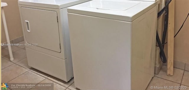 laundry area featuring independent washer and dryer and light tile patterned floors