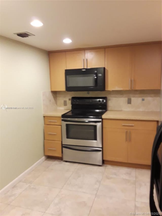 kitchen with stainless steel electric stove, tasteful backsplash, and light brown cabinetry