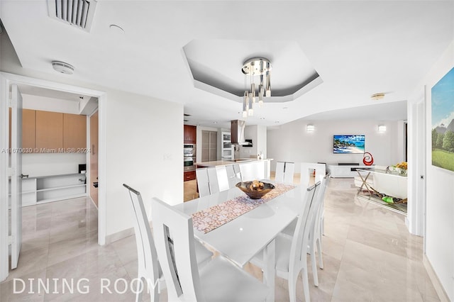 dining area with a raised ceiling