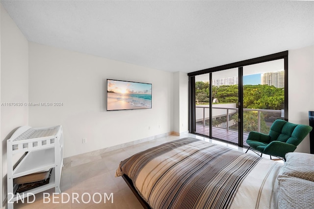 bedroom featuring a textured ceiling, access to outside, and expansive windows