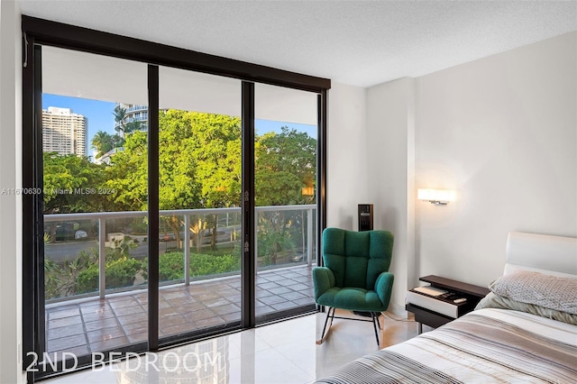 bedroom with light tile patterned flooring, a wall of windows, a textured ceiling, and access to outside