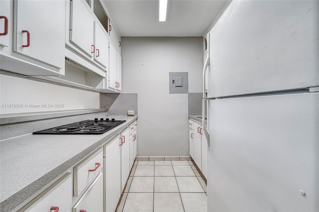 kitchen featuring white refrigerator, white cabinets, electric panel, light tile patterned floors, and black electric cooktop