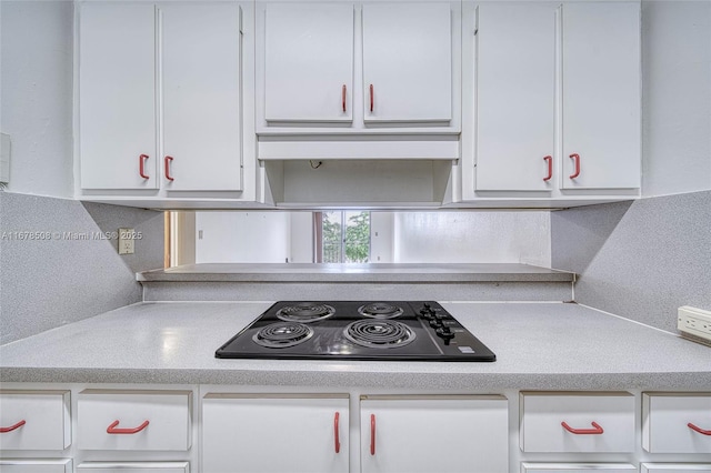 kitchen with white cabinets, black electric stovetop, ventilation hood, and tasteful backsplash