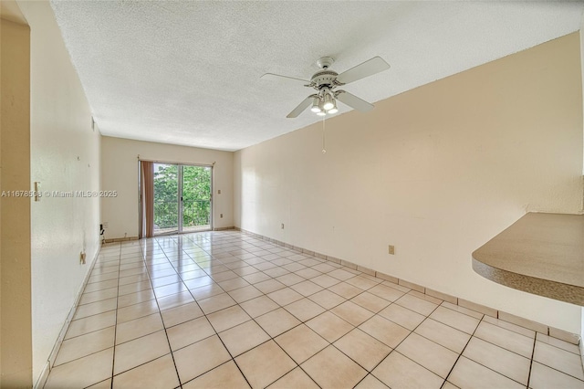 spare room featuring light tile patterned flooring, a textured ceiling, and ceiling fan