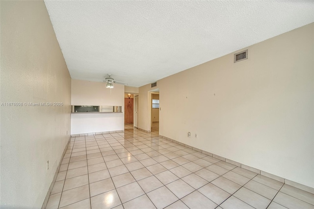 tiled empty room featuring a textured ceiling and ceiling fan