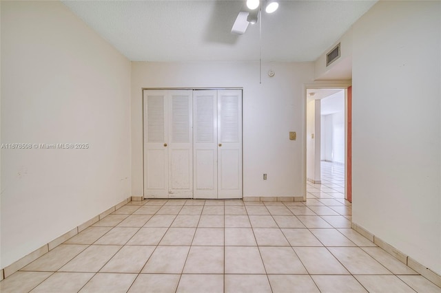 unfurnished bedroom with ceiling fan, a closet, and light tile patterned flooring