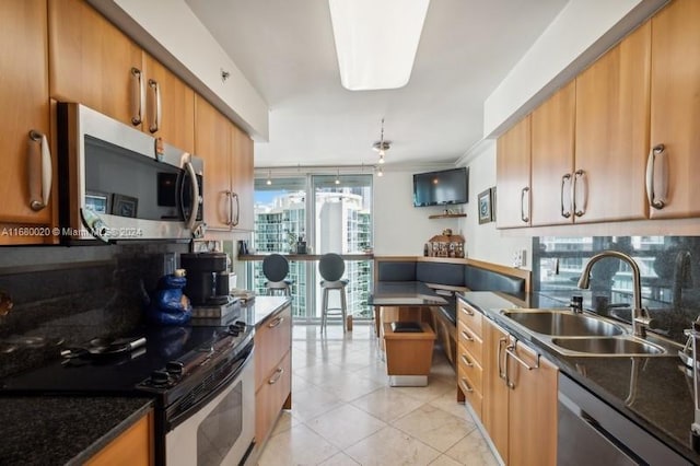 kitchen with dark stone countertops, appliances with stainless steel finishes, and sink