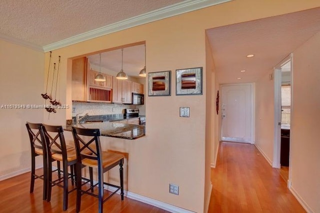 kitchen featuring dark stone counters, black appliances, ceiling fan, a textured ceiling, and light hardwood / wood-style floors