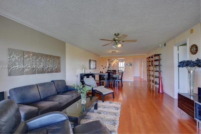 living room with hardwood / wood-style flooring, crown molding, ceiling fan, and a textured ceiling