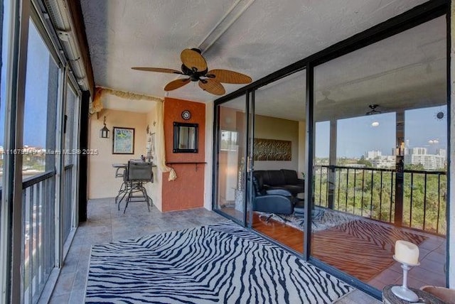 sunroom featuring ceiling fan and a wealth of natural light