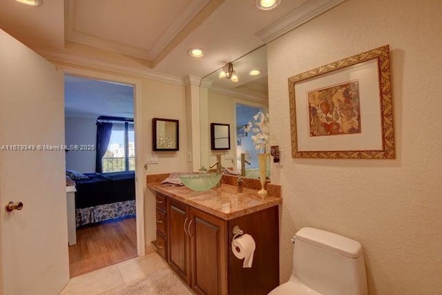 bathroom featuring crown molding, vanity, tile patterned floors, and toilet